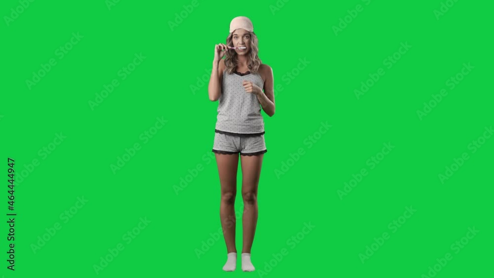 Cute happy young woman in sleepwear brushing teeth with toothbrush. Dental care. Full body isolated on green screen background Cute happy young woman in sleepwear brushing teeth with toothbrush. Dental care. Full body isolated on green screen background