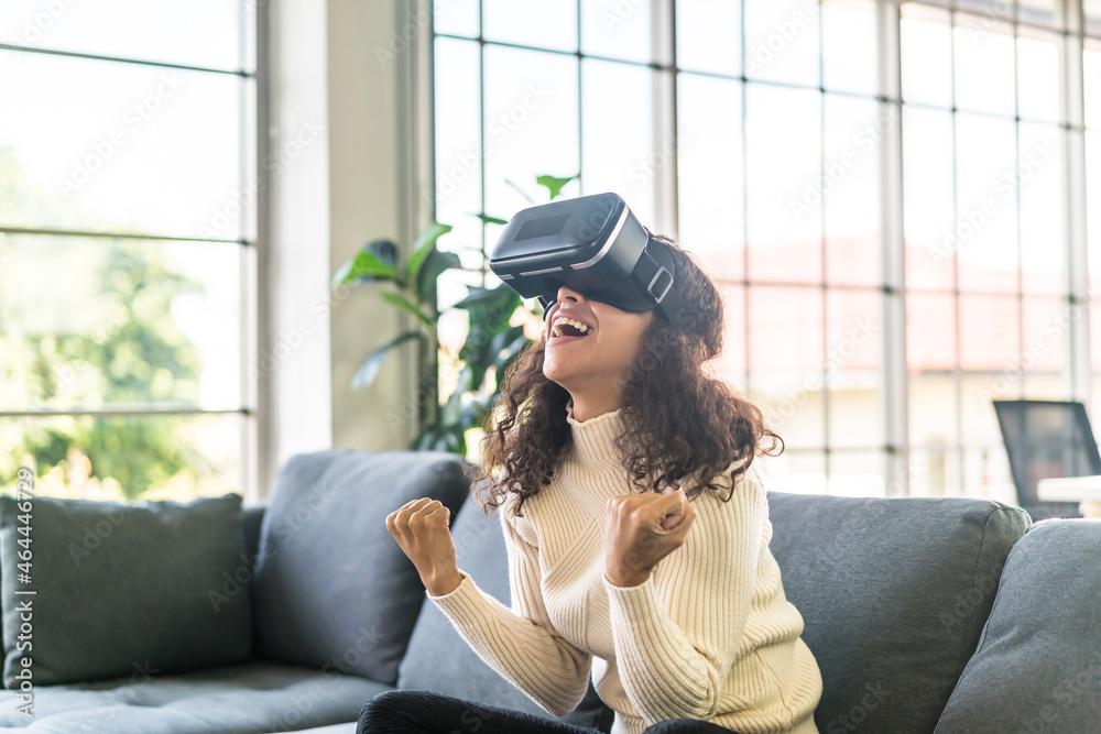 Latin woman using a virtual reality headset on sofa Latin woman using a virtual reality headset on sofa