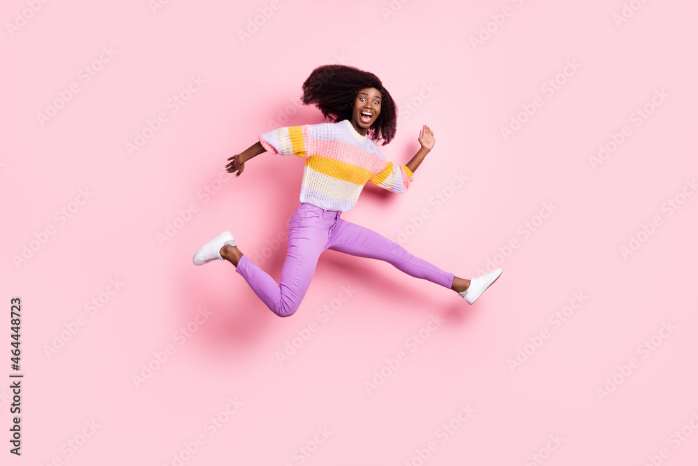 Full length profile portrait of childish dark skin person jumping open mouth isolated on pink color background