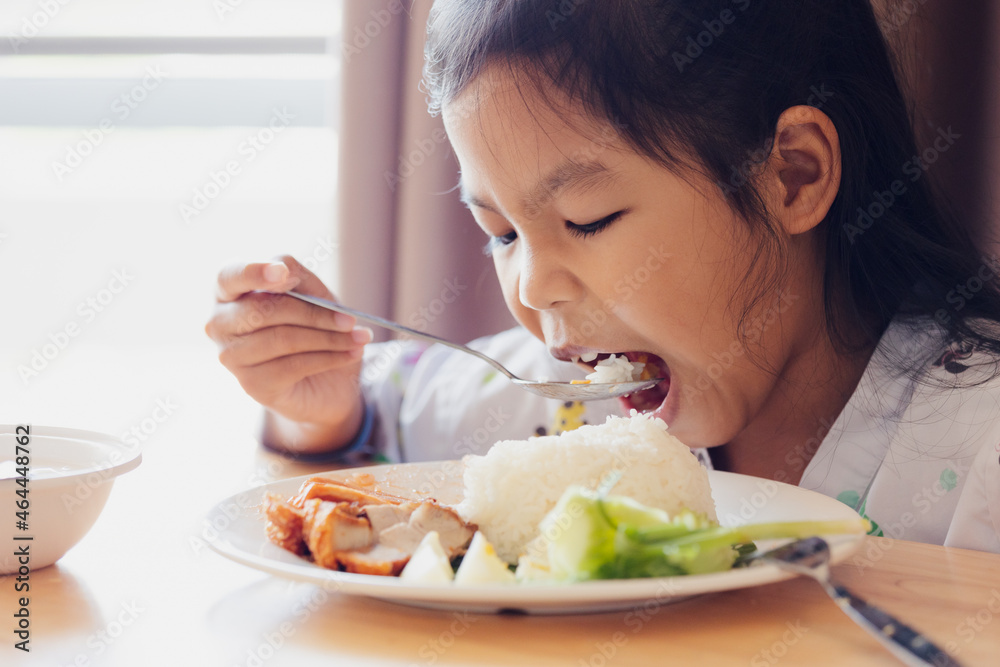 Sick asian child girl eating healthy food for lunch by herself while stay in private patient rooms in the hospital. Healthcare and lifestyle concept. Sick asian child girl eating healthy food for lunch by herself while stay in private patient rooms in the hospital. Healthcare and lifestyle concept.