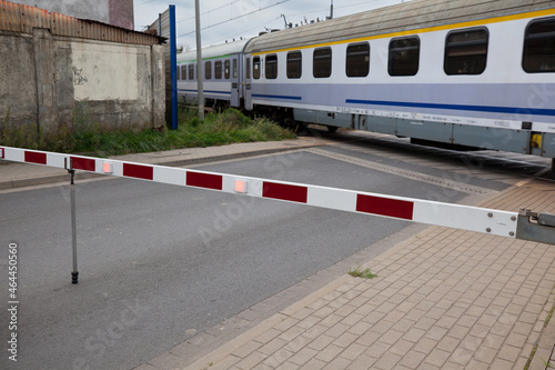 A train passing through a closed railroad crossing, city.