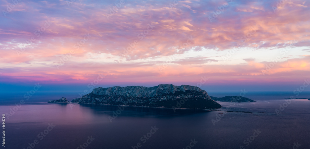 Fototapeta premium View from above, stunning aerial view of Tavolara Island during a dramatic sunset. Picture taken from Capo Ceraso, Sardinia, Italy.