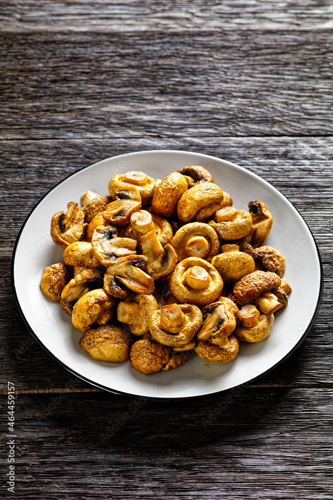 grilled juicy mushrooms on a plate, top view