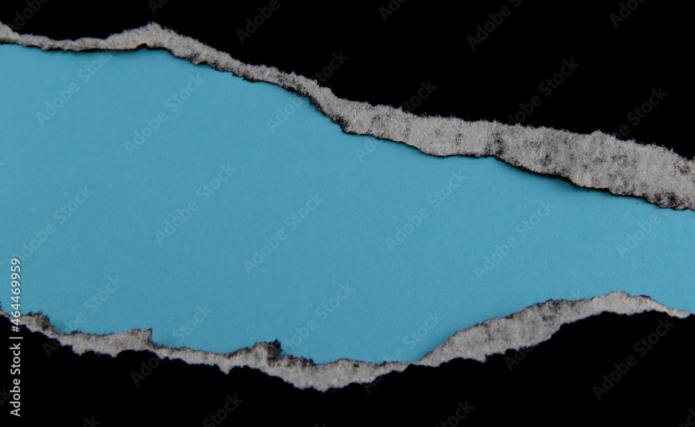 Black paper with torn marks placed on a blue paper background. The top corner image can be used as a background. with copy space and text area Black paper with torn marks placed on a blue paper background. The top corner image can be used as a background. with copy space and text area