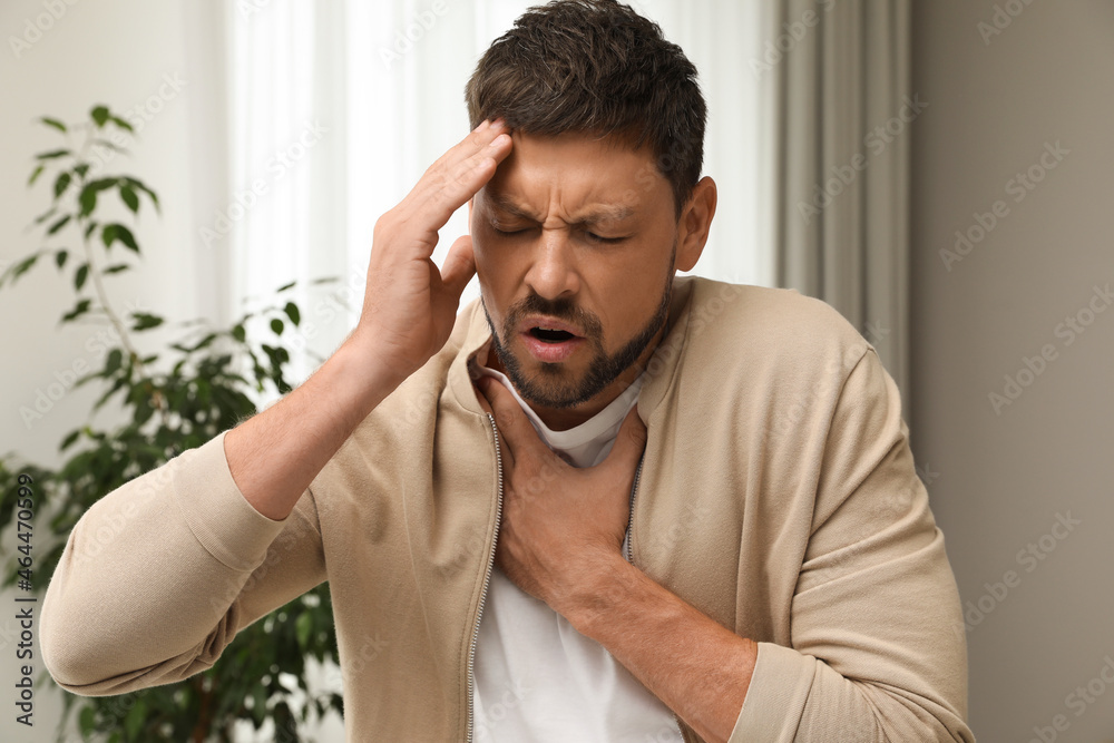 Man suffering from pain during breathing at home Man suffering from pain during breathing at home