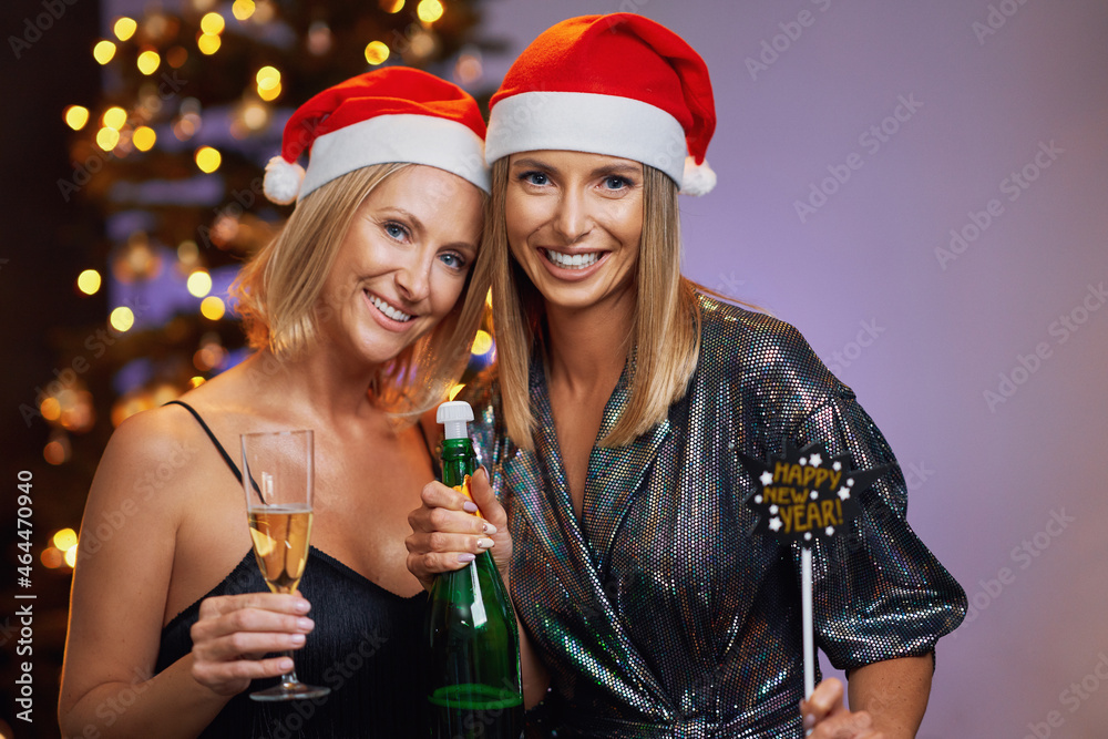 Young nice girlfriends or couple having fun on christmas or new year party