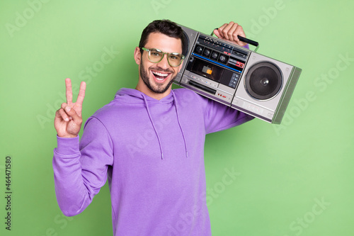 Quadro su tela Photo of funky young brunet guy hold boom box wear spectacles hoodie isolated on