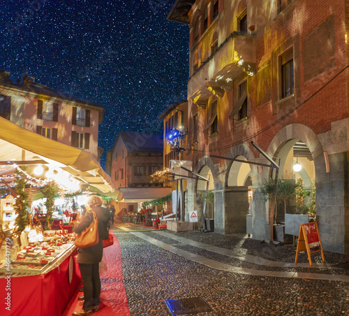 warm atmosphere at the christmas market with starry sky.Como,Italy.