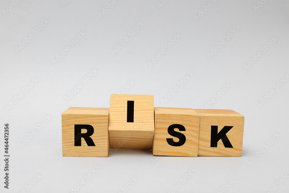 Wooden cubes with word Risk on light grey background Wooden cubes with word Risk on light grey background