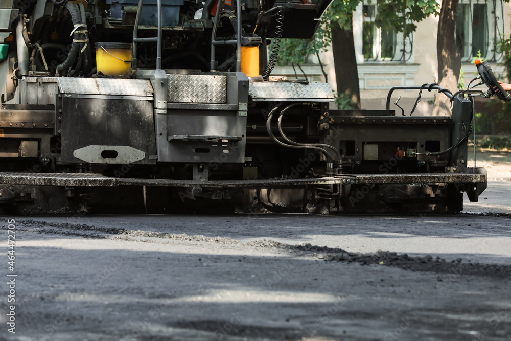 Modern asphalt finisher on city street. Road repair service Modern asphalt finisher on city street. Road repair service