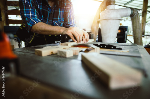 carpenter worker saws a wooden beam