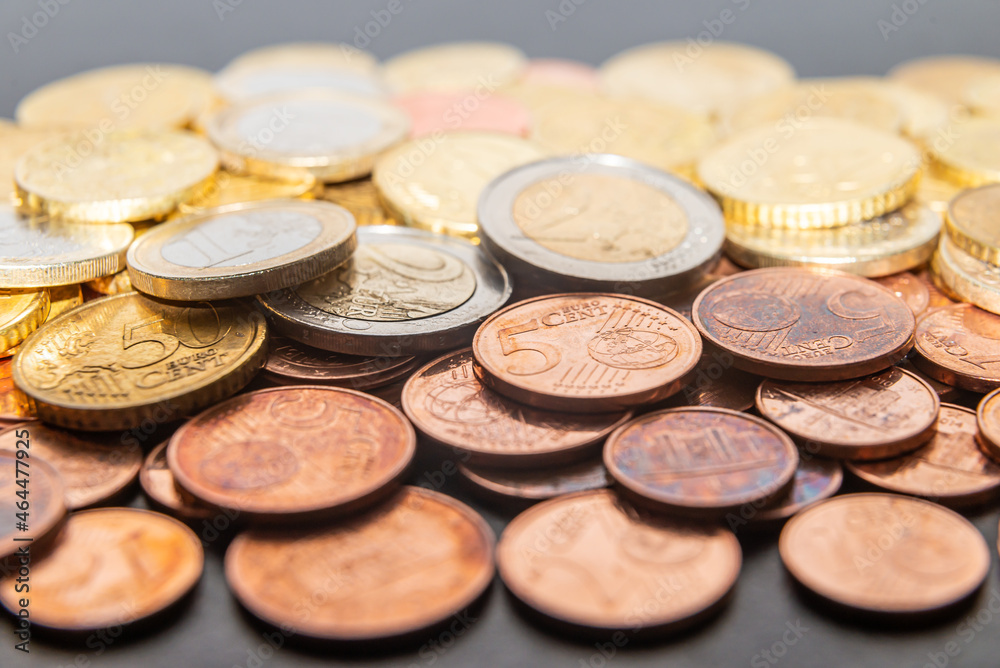 Coins and euro cents, on white surface. Wealth, savings, and rate hikes. Coins and euro cents, on white surface. Wealth, savings, and rate hikes.