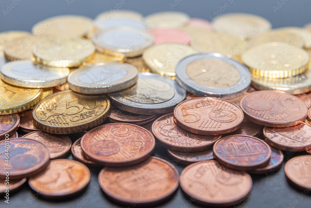 Coins and euro cents, on white surface. Wealth, savings, and rate hikes. Coins and euro cents, on white surface. Wealth, savings, and rate hikes.