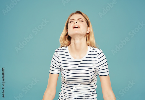 blonde girl in striped t-shirt fun glamor posing blue background