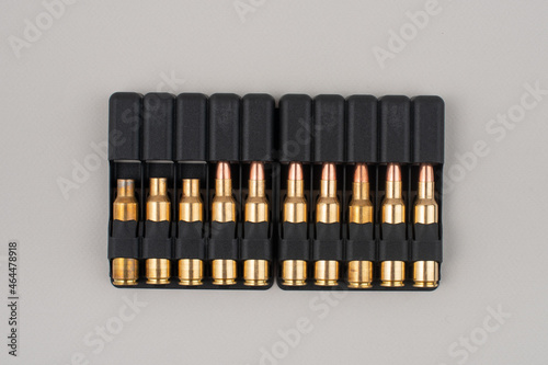 Rifle bullets in plastic cases isolated on grey background.