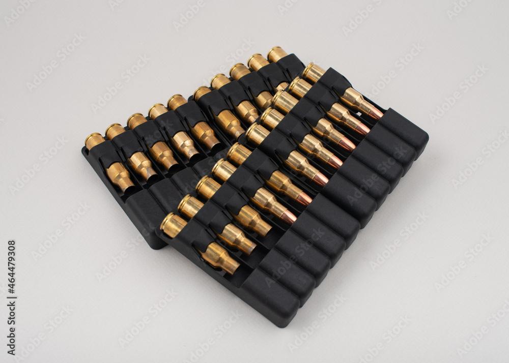 Rifle bullets in plastic cases isolated on grey background. Rifle bullets in plastic cases isolated on grey background.
