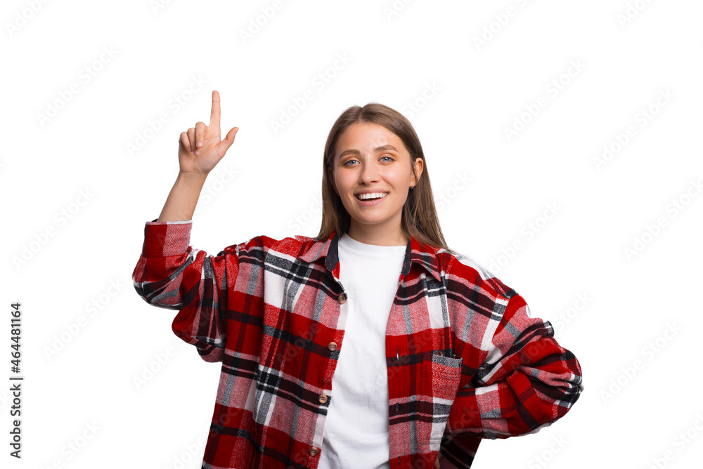 Smiling cheerful woman is pointing up, over white background.