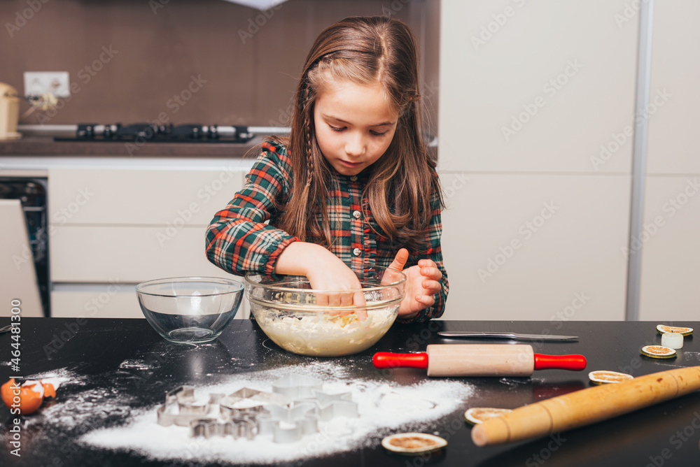 Beautiful little girl is preparing dough for gingerbreaad cookies. Beautiful little girl is preparing dough for gingerbreaad cookies.
