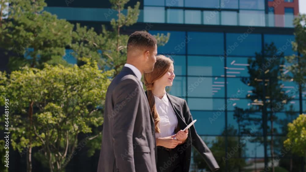 In a perfect sunny day charismatic black man and woman business workers meeting in front of modern business centre they end the discussion and shaking hands. 4k