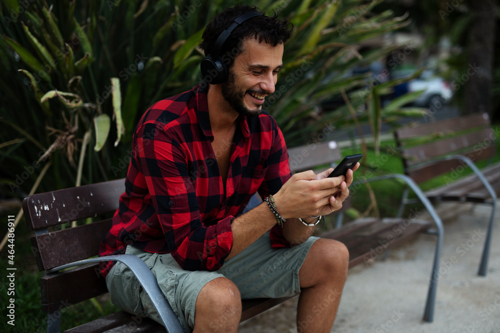 Obraz premium Young man listening to music. Urban fashion man with headphones enjoying the city.