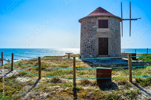 Wooden fence with cord around a windmill in backlit landscape with sea on the horizon, Apúlia - Esposende PORTUGAL photo