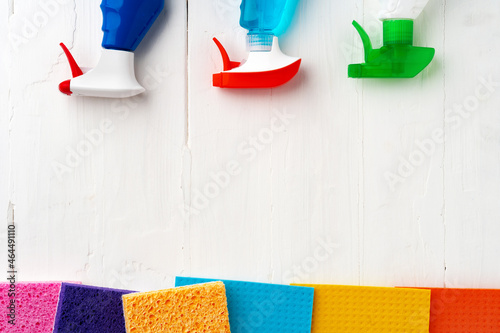 Home cleaning supplies on white wooden background, top view