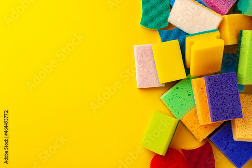 Pile of new cleaning sponges on yellow background  top view