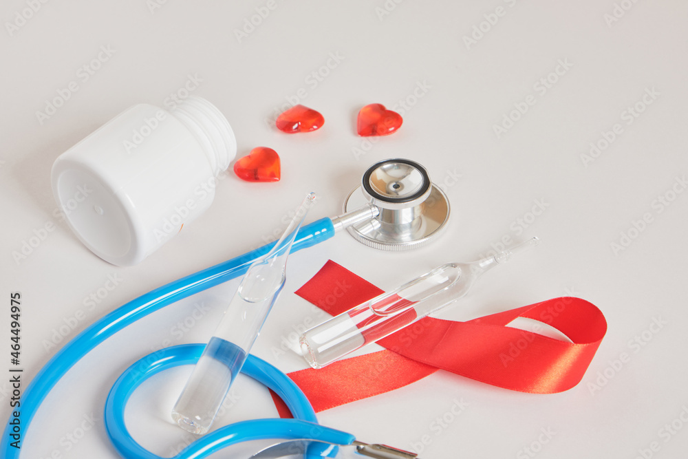 Red ribbon and blue medical stethoscope Healthcare and safe sex concept. Red ribbon and blue medical stethoscope Healthcare and safe sex concept.