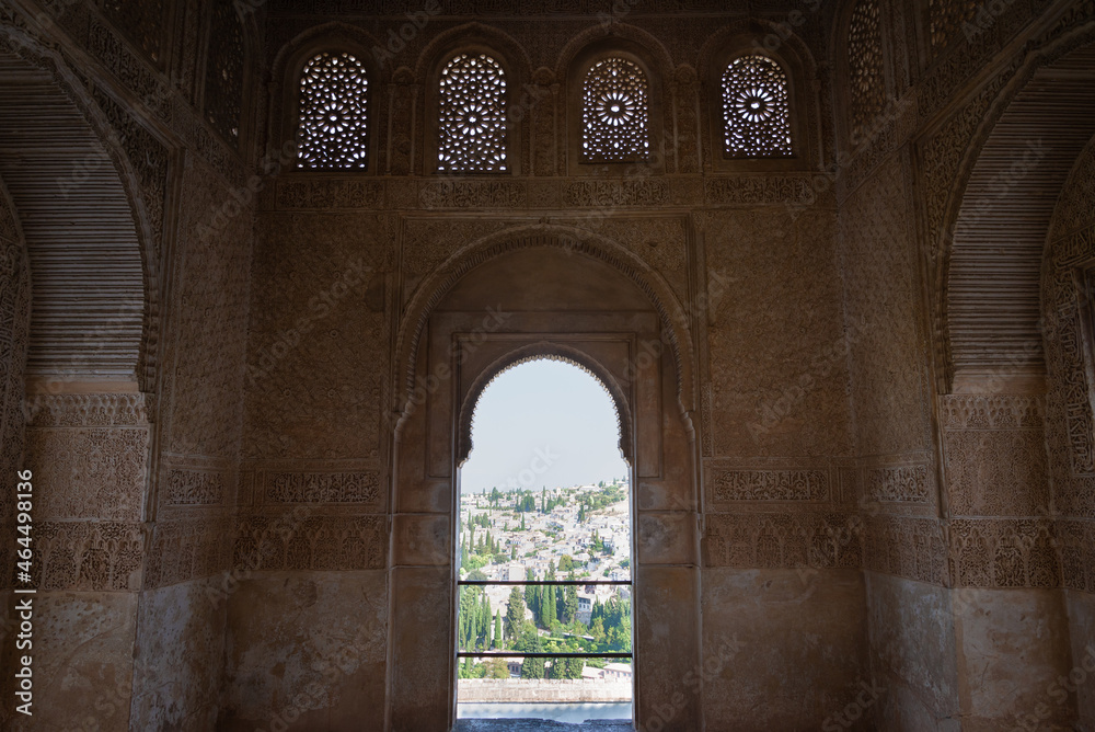 Beautiful arch in moorish style, with walls decorated with arabesque and a window with landscape view of Granada, Andalucia, Spain.
