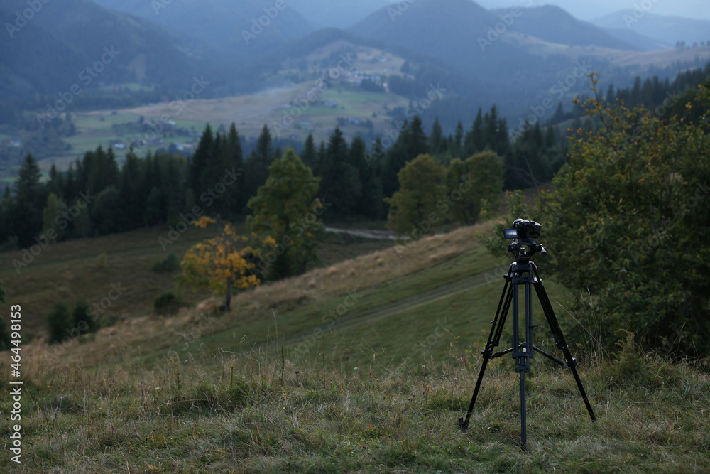 Taking photo of beautiful mountain landscape with camera mounted on tripod outdoors, space for text
