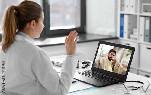 healthcare, technology and medicine concept - female doctor having video call with sick man patient on laptop computer at hospital