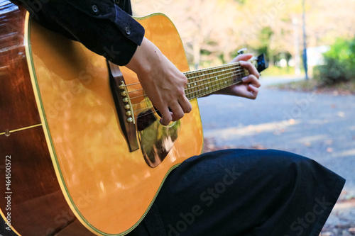 森の中でアコースティックギターを弾く女性