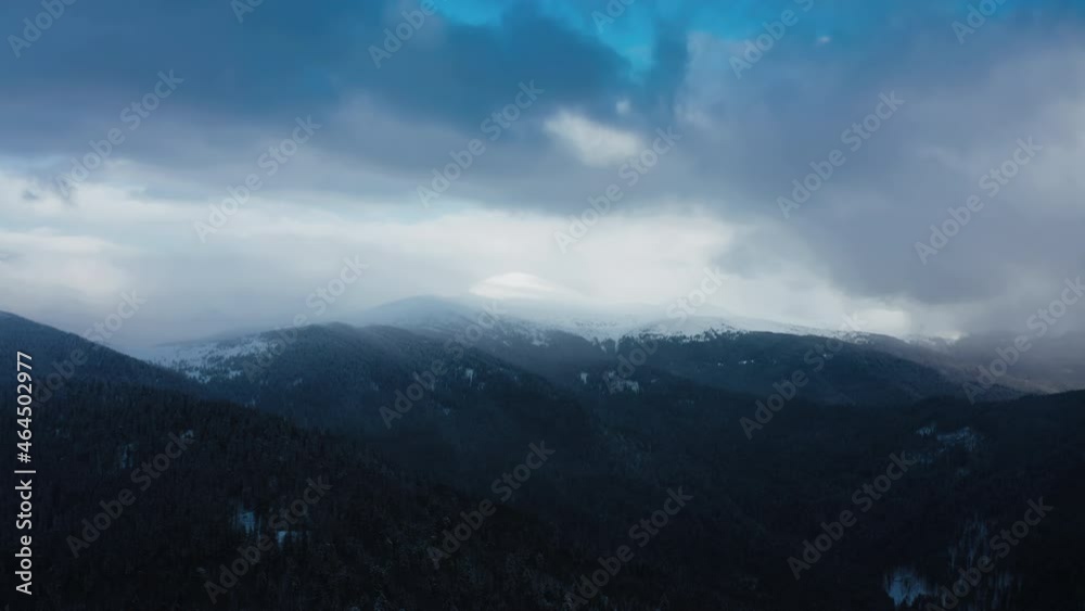 Aerial snowy forest. Mountainside Landscape in Winter Season. Flight Over Mountain. Drone Footage Cinematic Quality