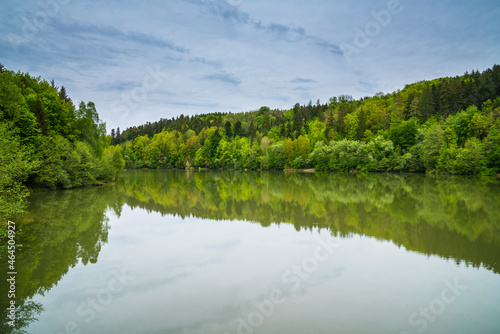 Germany, Calm herrenbachstausee lake water surrounded by green forest and nature landscape near adelberg and goeppingen