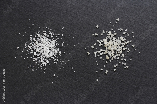 Two different types of traditional salt of high quality: the salt flower on the left and the coarse sel on the right on a black background.  photo