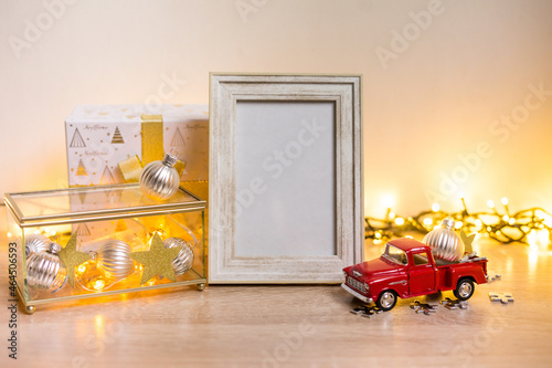 Portrait white picture frame mockup with christmas gifts, boken lights photo