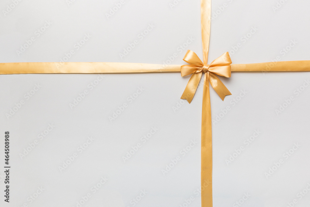 Top view of gold ribbon rolled and yellowbow isolated on colored background. Flat lay with copy space Top view of gold ribbon rolled and yellowbow isolated on colored background. Flat lay with copy space