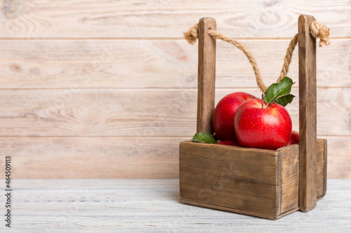 Ripe red apples in wooden box. On a white wooden background