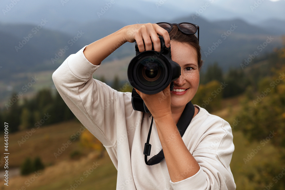 Obraz premium Professional photographer taking picture with modern camera in mountains