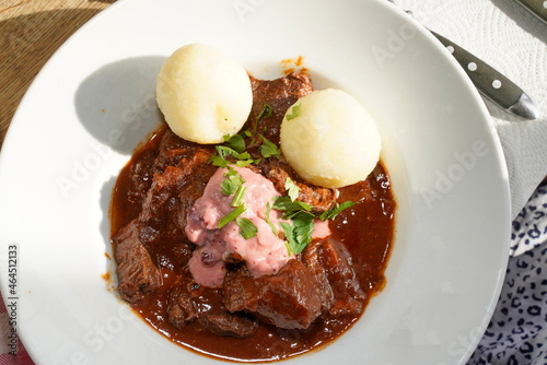 Wildgulasch mit Kartoffelknödeln und Preiselbeer Rahmsoße photo