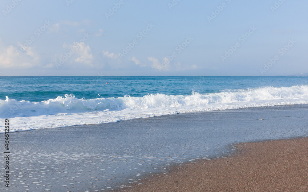 Waves on the beach. Sand and blue water. Sicily, Italy.