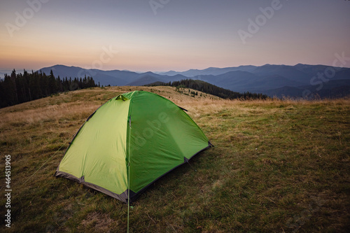 dawn in the mountains. mountain peak with tent and sunrise