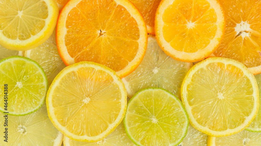 Background with sliced citrus fruits. Sliced oranges, lemons and limes top view. Citrus banner