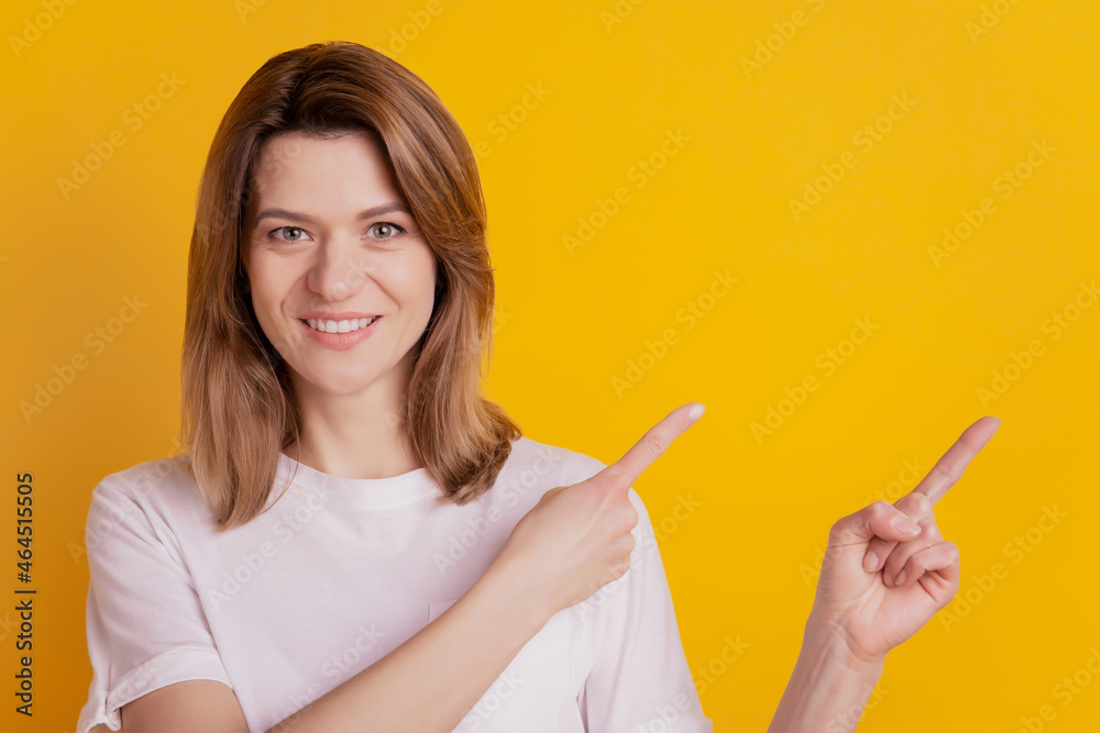 Photo of promoter adviser lady indicate finger empty space wear casual clothes on yellow background Photo of promoter adviser lady indicate finger empty space wear casual clothes on yellow background