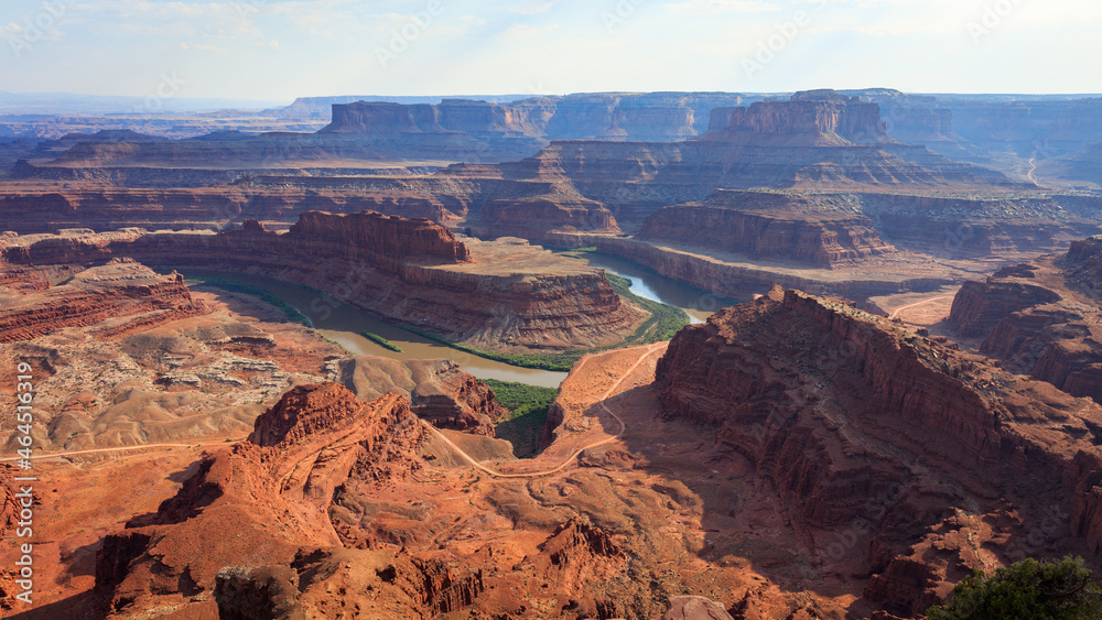 Dramatic desert view overlooking river winding through red canyon landscape on a hot summer evening. Taken at Dead Horse Point State Park, overlooking Colorado River and Canyonlands, Utah.