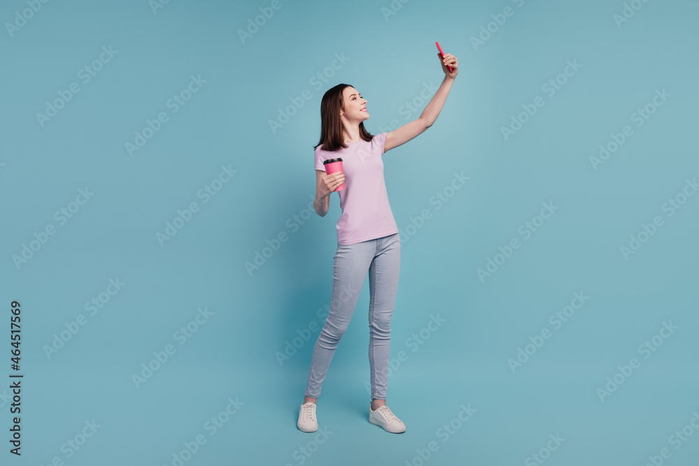 Full size photo of young cheerful girl drink coffee make selfie smartphone isolated turquoise color background Full size photo of young cheerful girl drink coffee make selfie smartphone isolated turquoise color background
