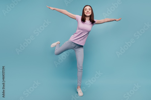 Full body photo of cheerful girl good mood hands wings fly plane casual outfit isolated over teal color background © Tetiana