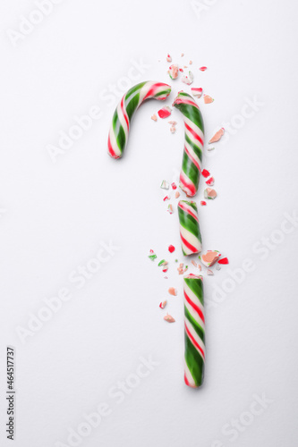 Broken sweet Christmas candy cane on white background, top view
