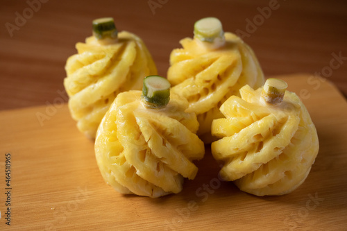 Small Phulae pineapple on a wooden chopping board photo