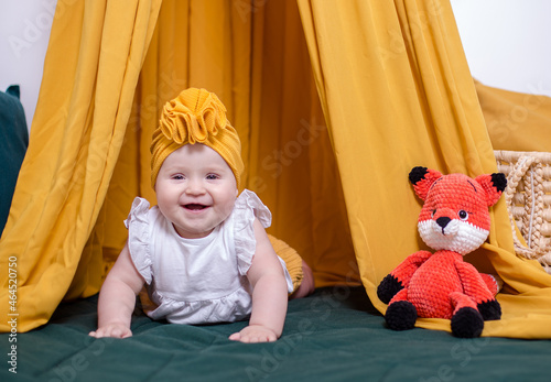 cute baby girl posing. A fashionable Baby is photographed for advertising.Fashionable baby in a yellow turban